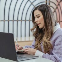 起業マインドセットを持つ女性経営者がノートに思考を書き出している様子