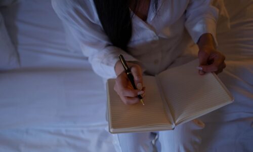 起業前夜に不安を抱えながらメモを書く女性の手元 - 起業の不安解消のイメージ